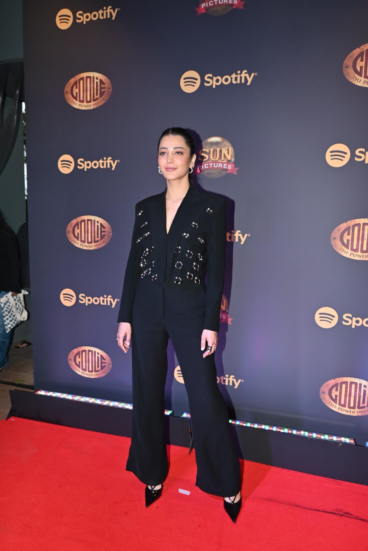 Shruti Haasan looked classy and chic as she arrived for the musical event of her upcoming film Coolie in the city today. She wore a classy black suit which featured golden circular designs. She paired it with a sleek braid and stilettos.